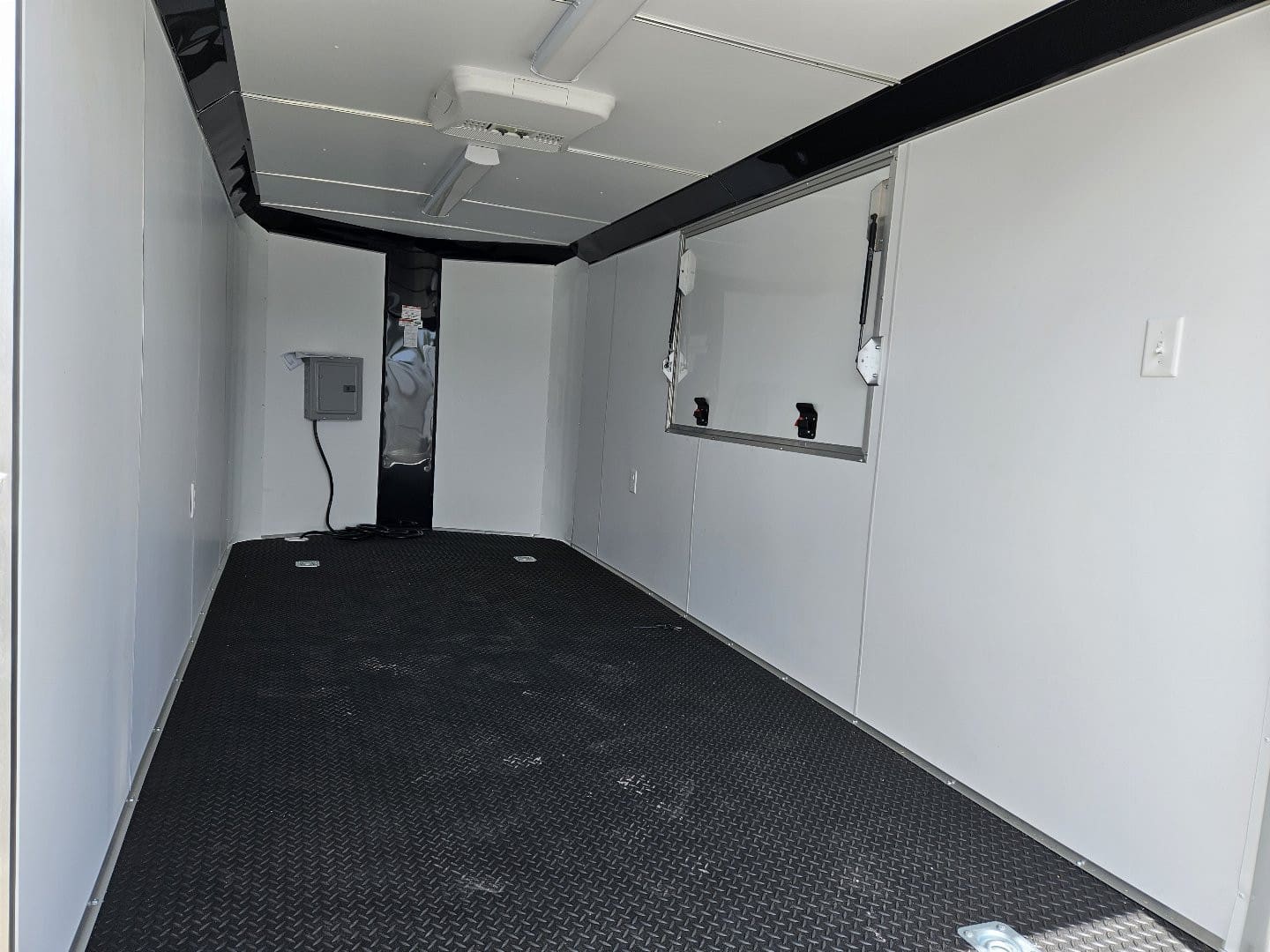 Empty trailer interior with black flooring.