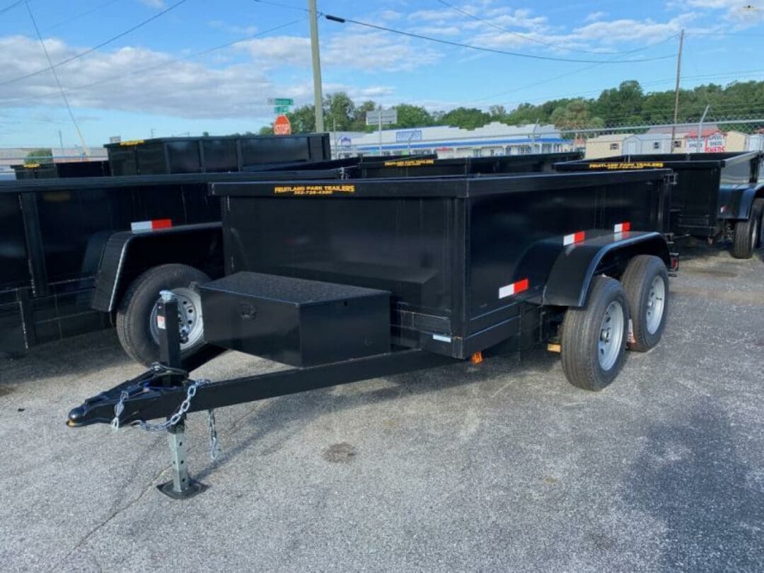 Black utility trailer parked on asphalt