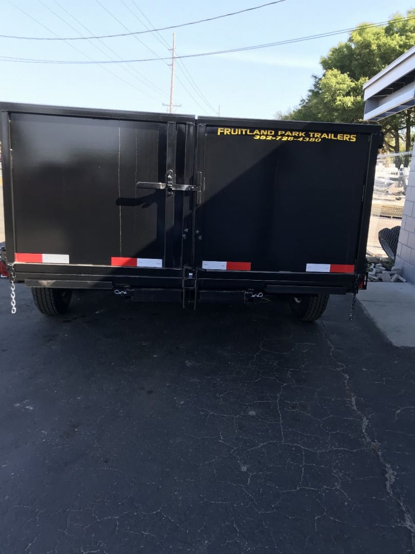 Black utility trailer parked on pavement