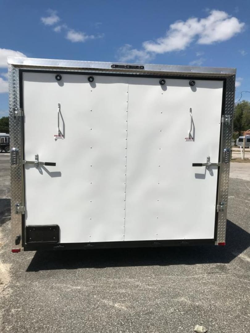 White cargo trailer under clear blue sky.