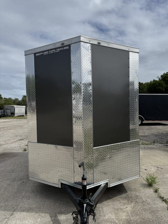 Silver utility trailer under cloudy sky