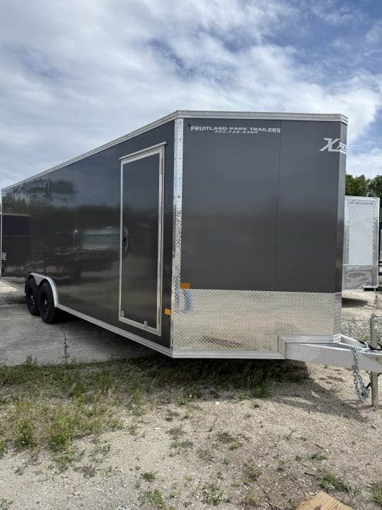 Enclosed cargo trailer on gravel lot.