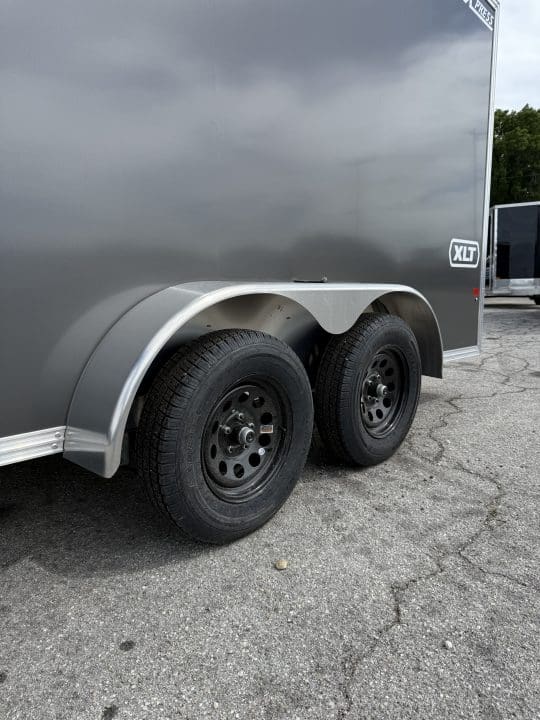 Gray trailer with black wheels outdoors