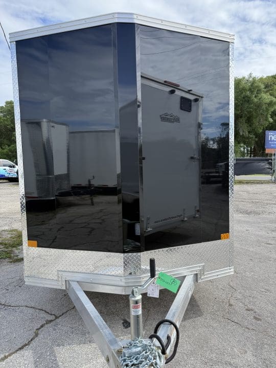 Black utility trailer in parking lot