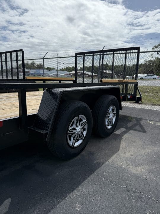 Utility trailer on asphalt under cloudy sky